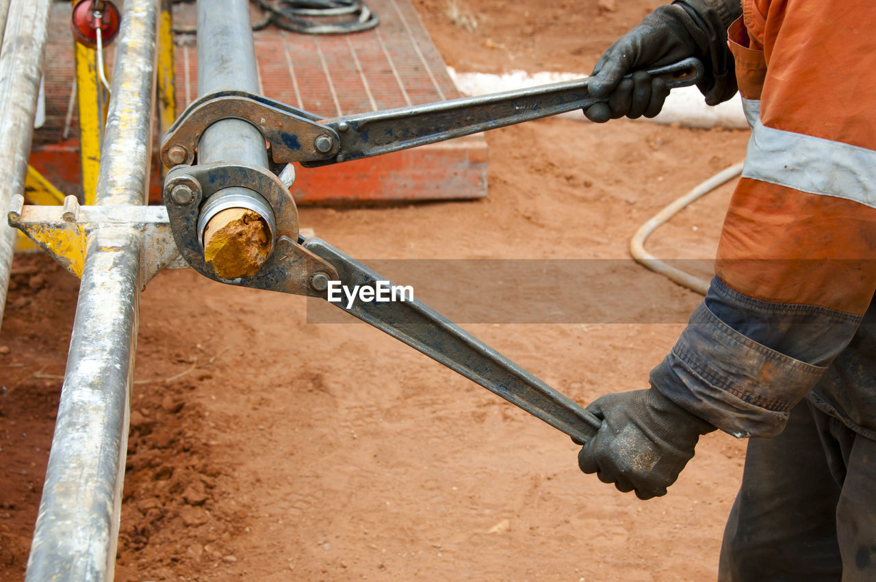 Midsection of worker working on field