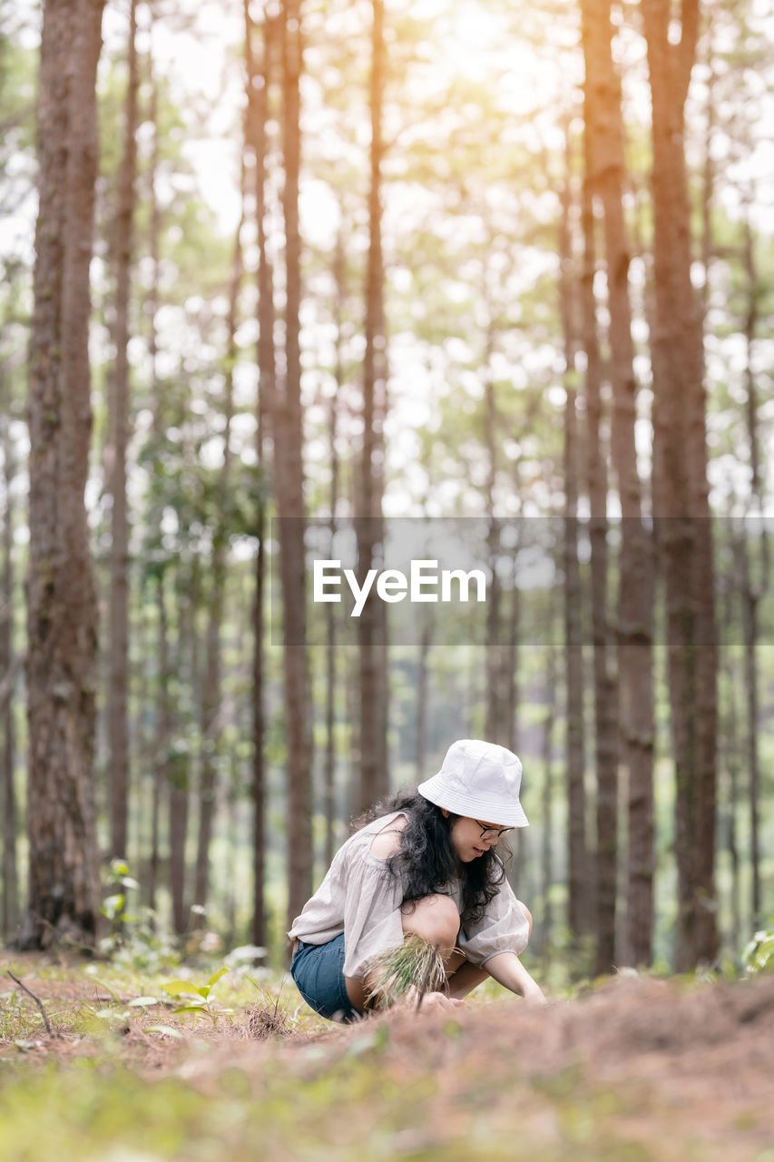 WOMAN ON ROCK IN FOREST