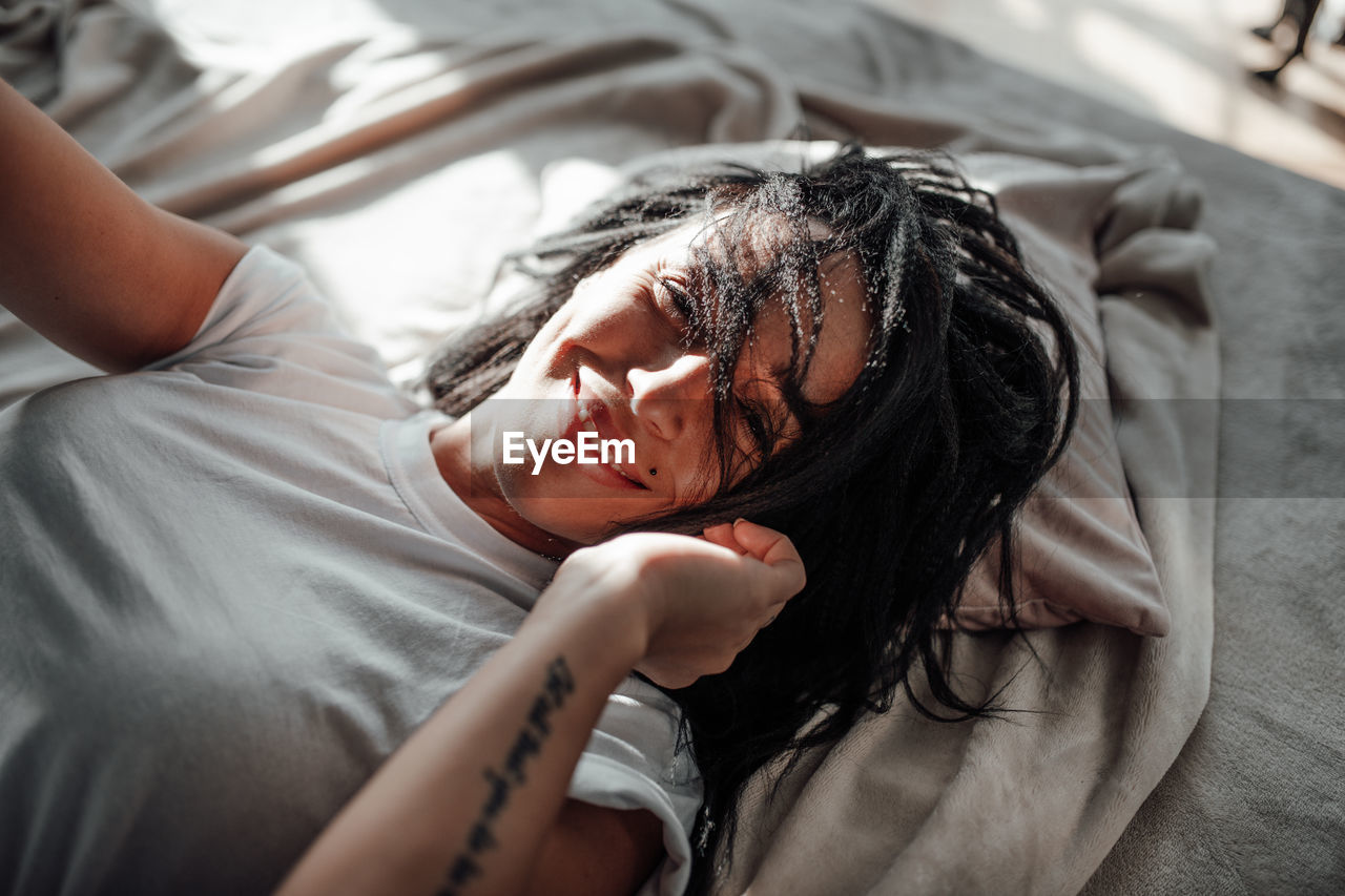 Portrait of woman lying on bed at home