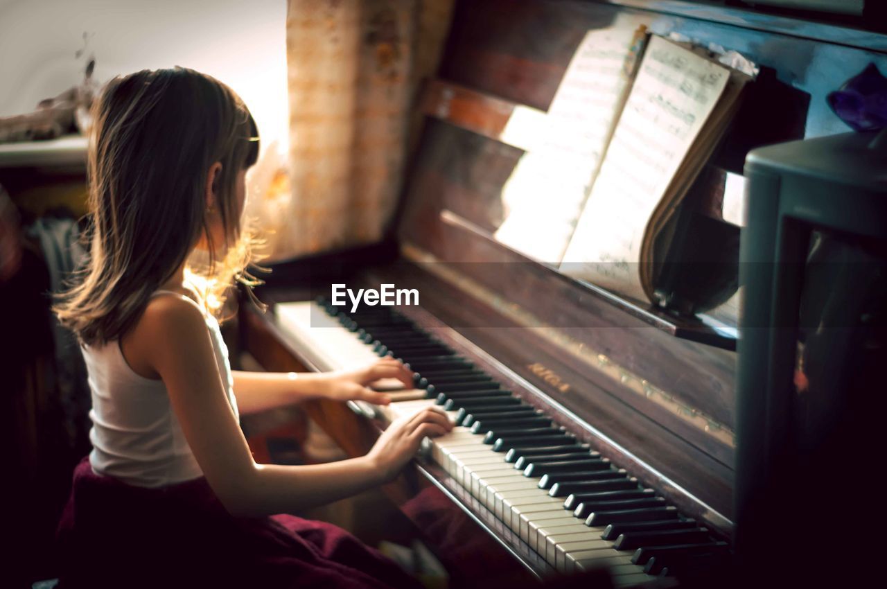 Girl playing piano at home