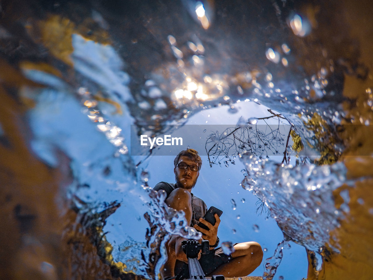 LOW ANGLE VIEW PORTRAIT OF YOUNG MAN IN WATER