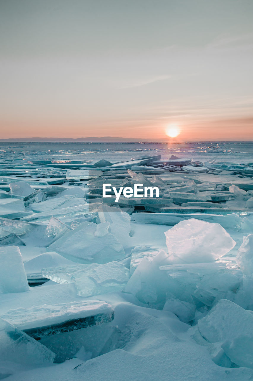 Scenic view of frozen sea against sky during sunset