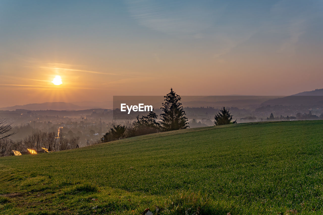 Scenic view of field against sky during sunset