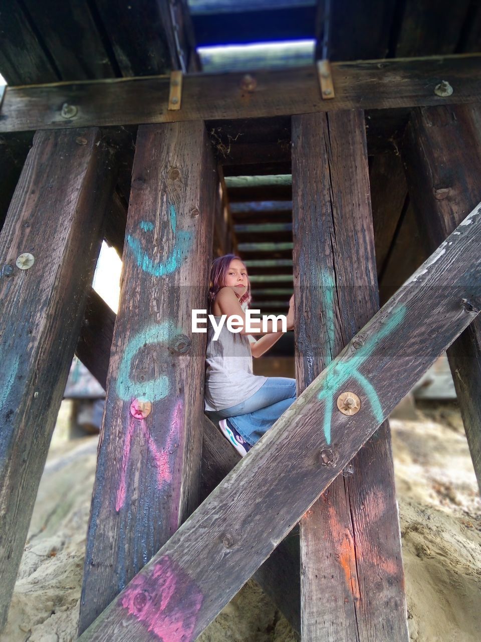 Rear view of woman sitting on railing