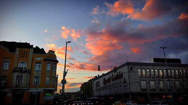 LOW ANGLE VIEW OF BUILDINGS AGAINST CLOUDY SKY AT SUNSET