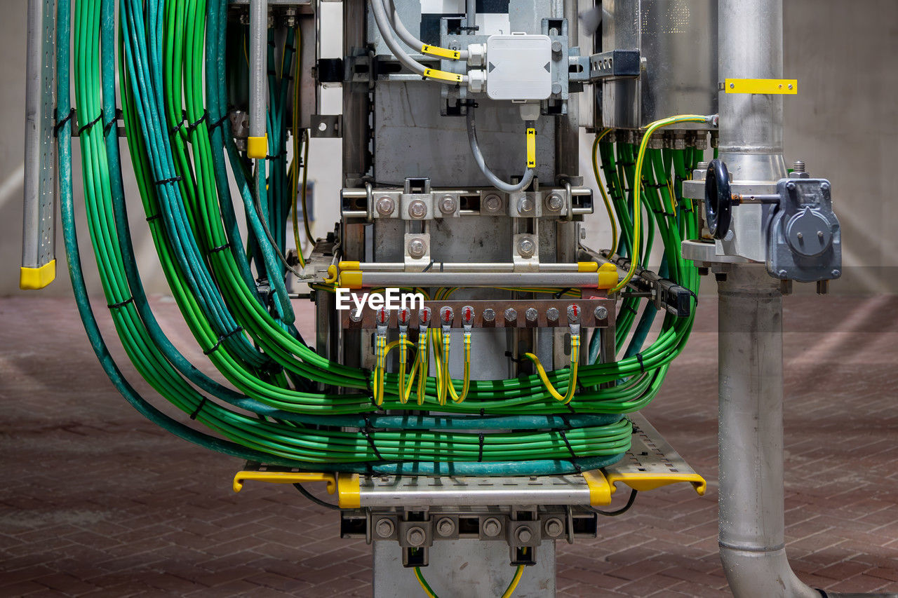 Picture of yellow colored electrical grounding cables and green signal cables in a industrial area