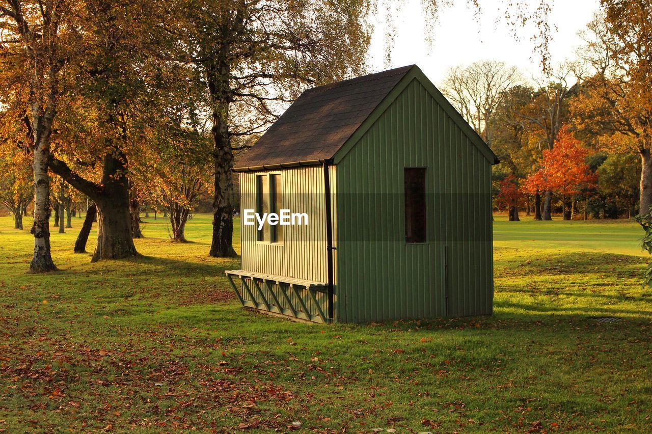 House by trees on field during autumn