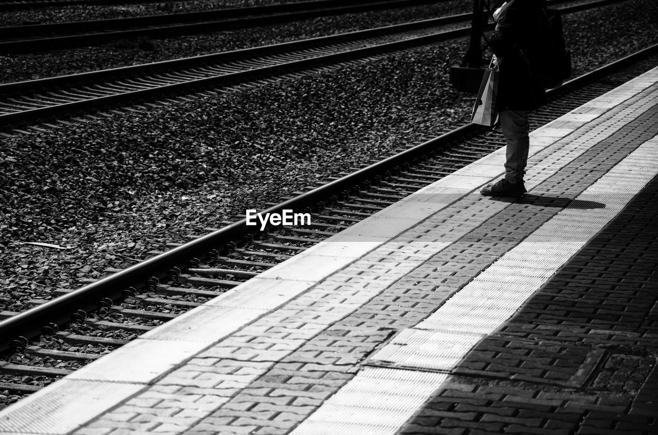 LOW SECTION OF PERSON STANDING ON RAILWAY TRACKS