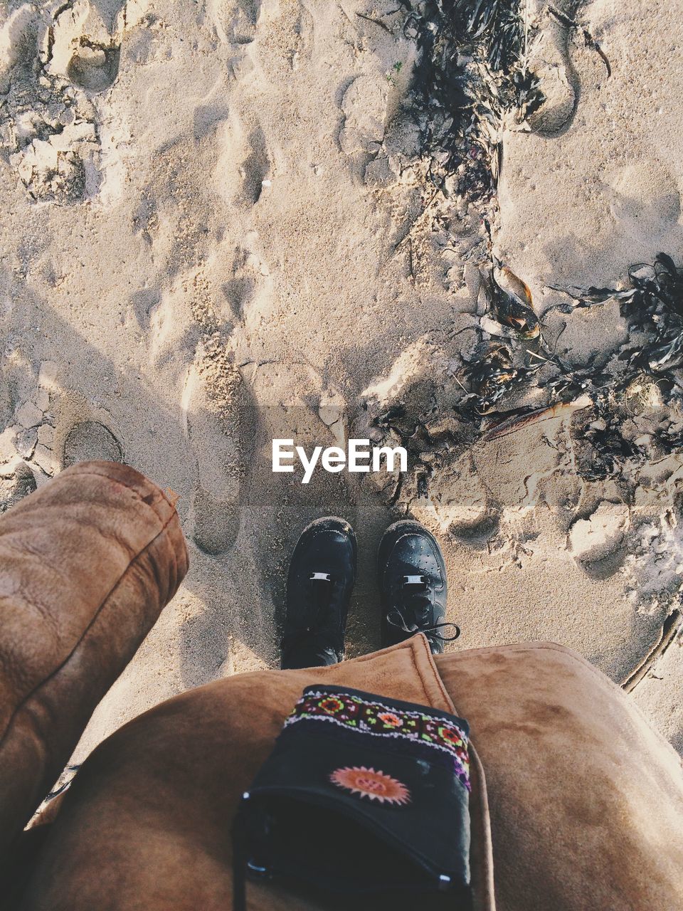 Low section of person standing on sand