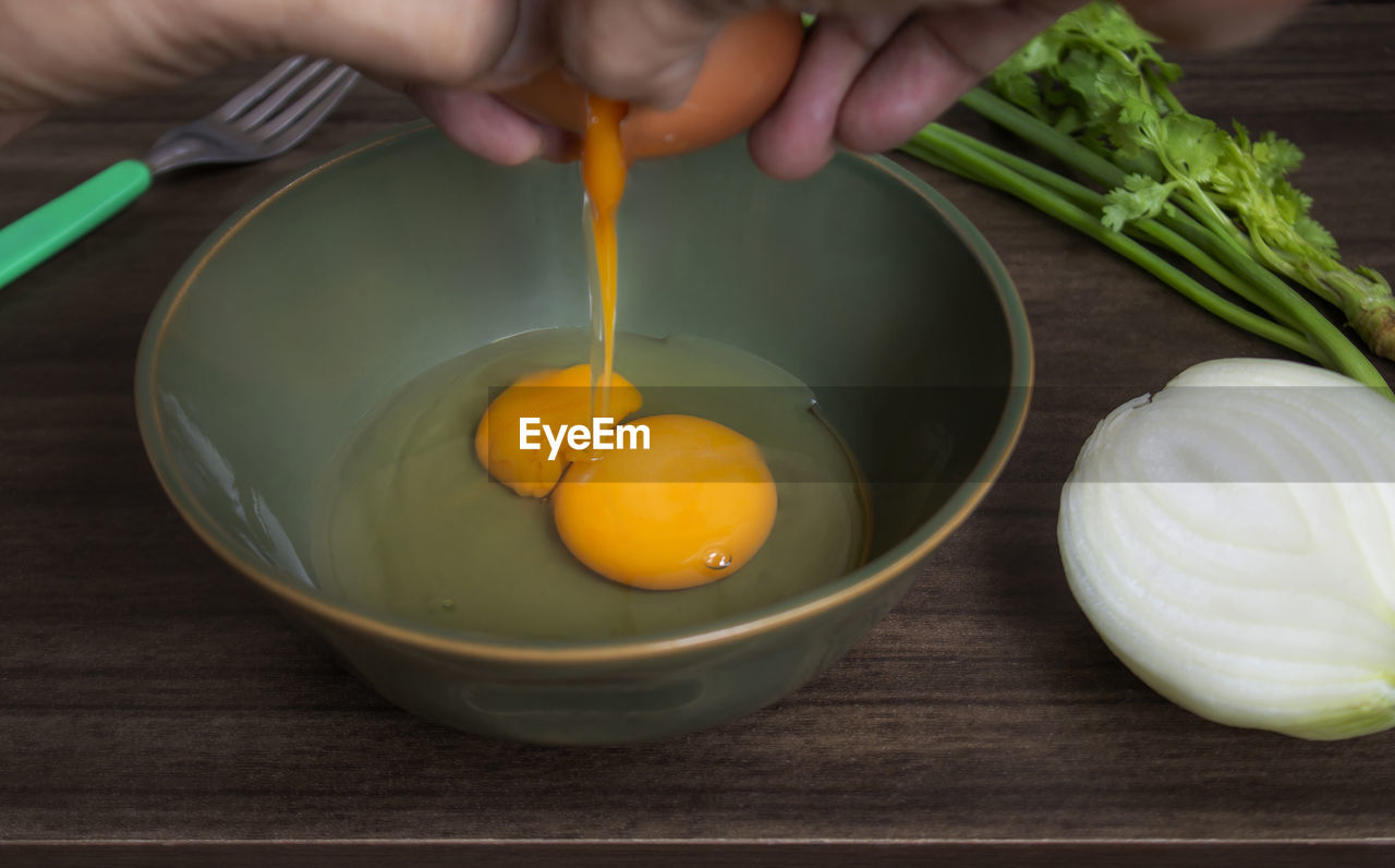 cropped hand of man preparing food on table