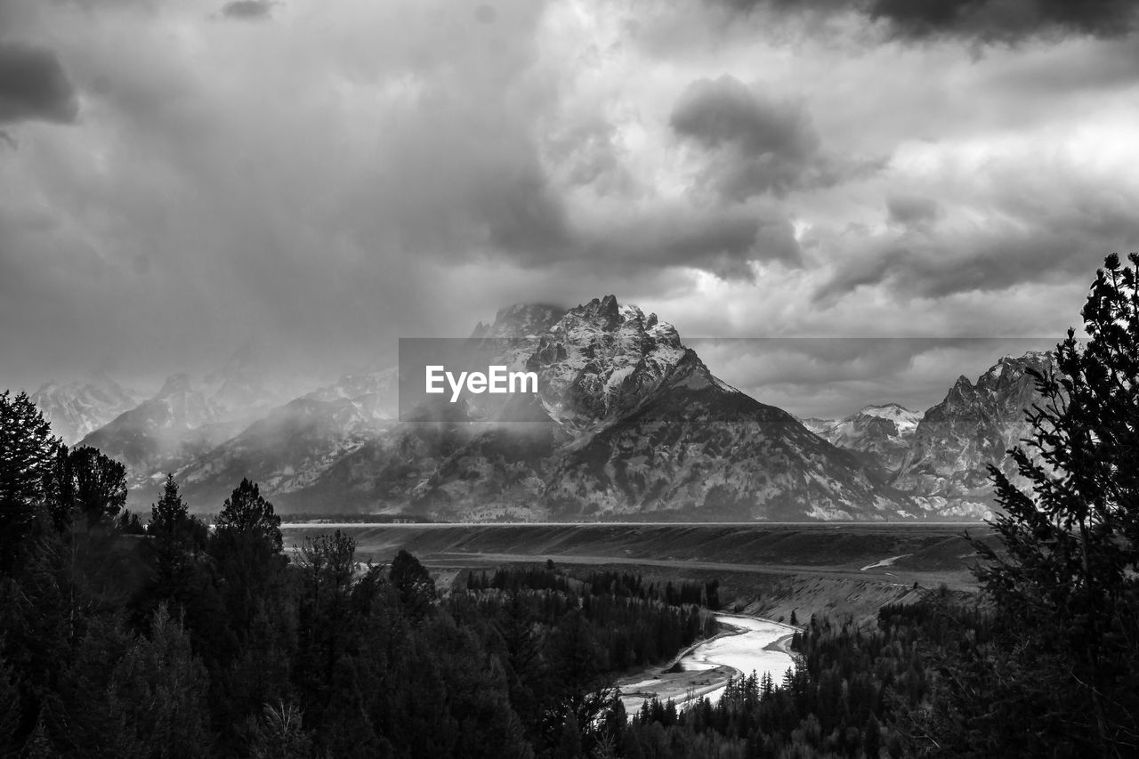 Scenic view of lake and mountains against cloudy sky