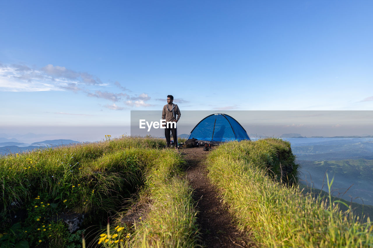 Man standing on mountain against sky