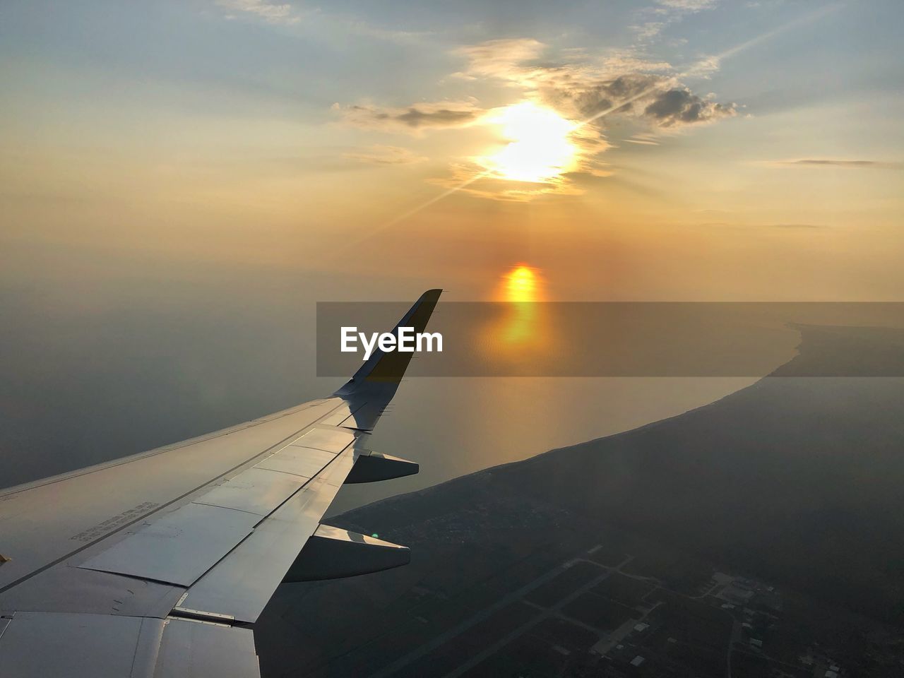 Aircraft wing against sky during sunset