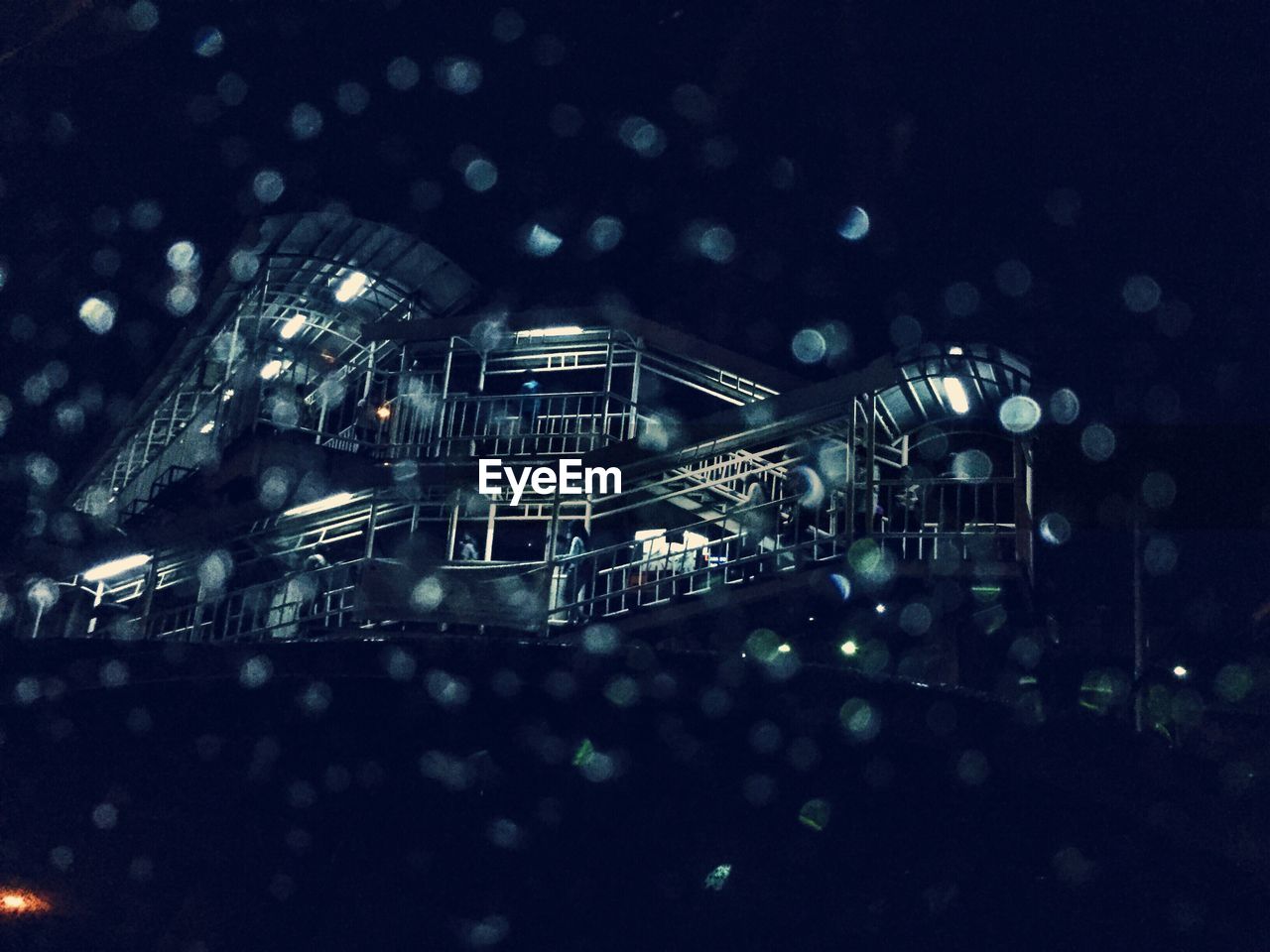 Low angle view of building at night during rainy season