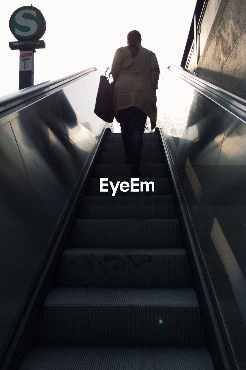 Low angle view of woman on escalator