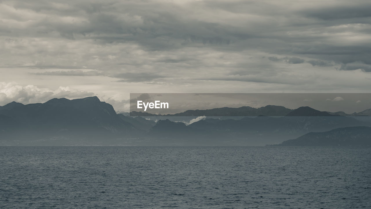 Scenic view of sea and mountains against sky