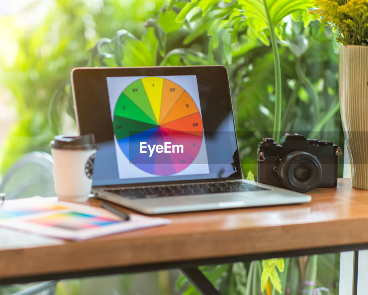 Close-up of digital camera and laptop on table