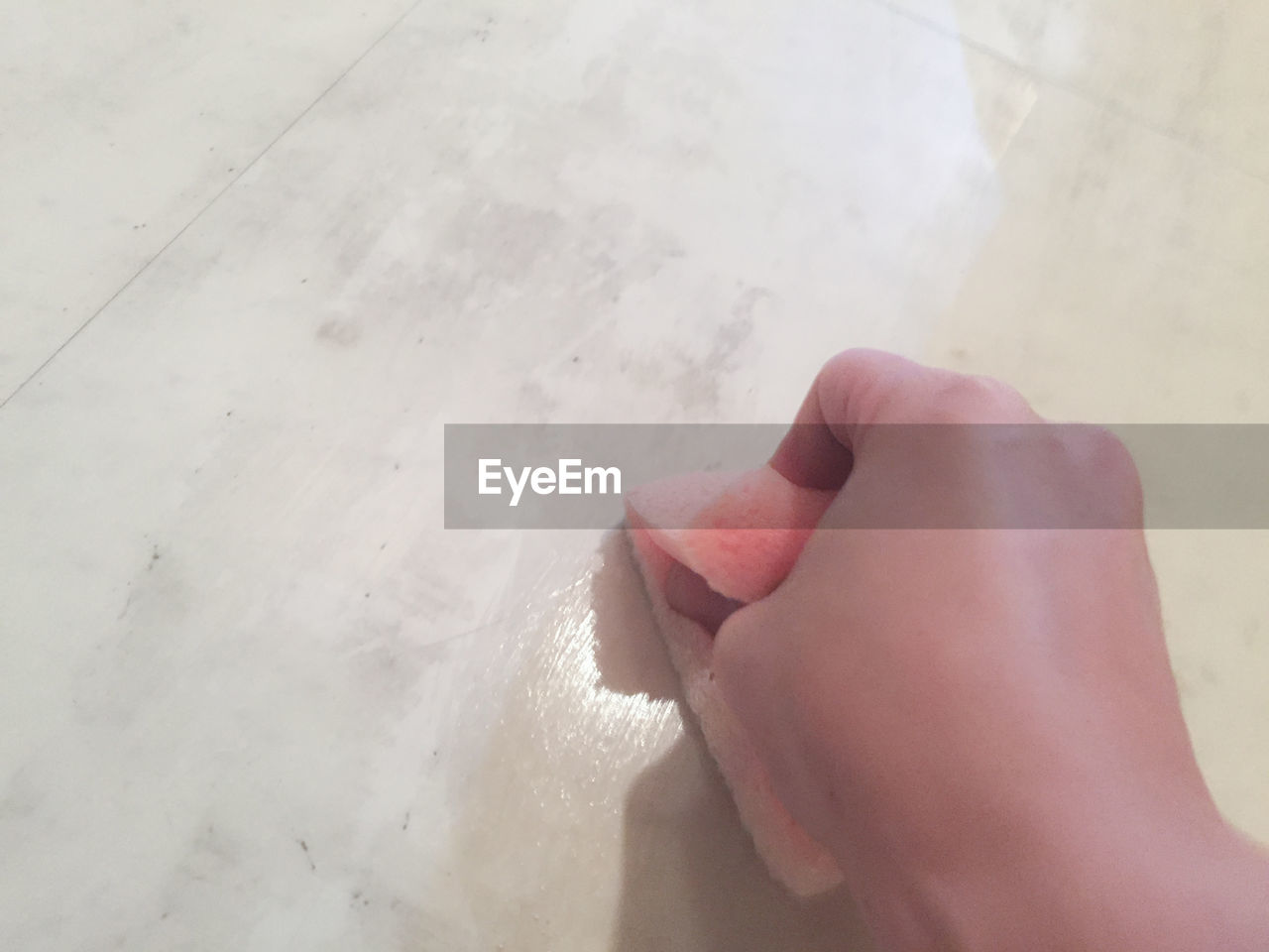 Cropped image of woman hand cleaning tiled floor