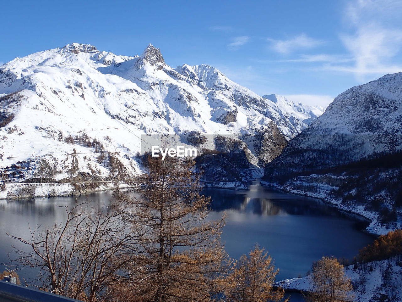 Scenic view of lake by snowcapped mountains against sky