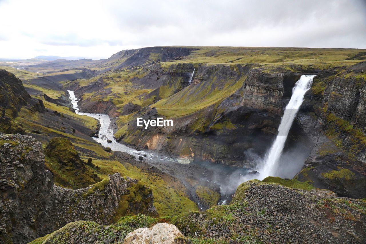 Scenic view of waterfall against sky