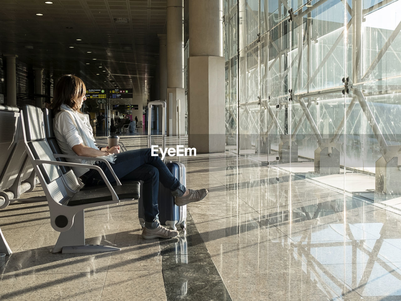 Pretty, young woman waiting at a gate area of a modern airport