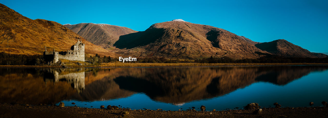 scenic view of lake and mountains against clear sky