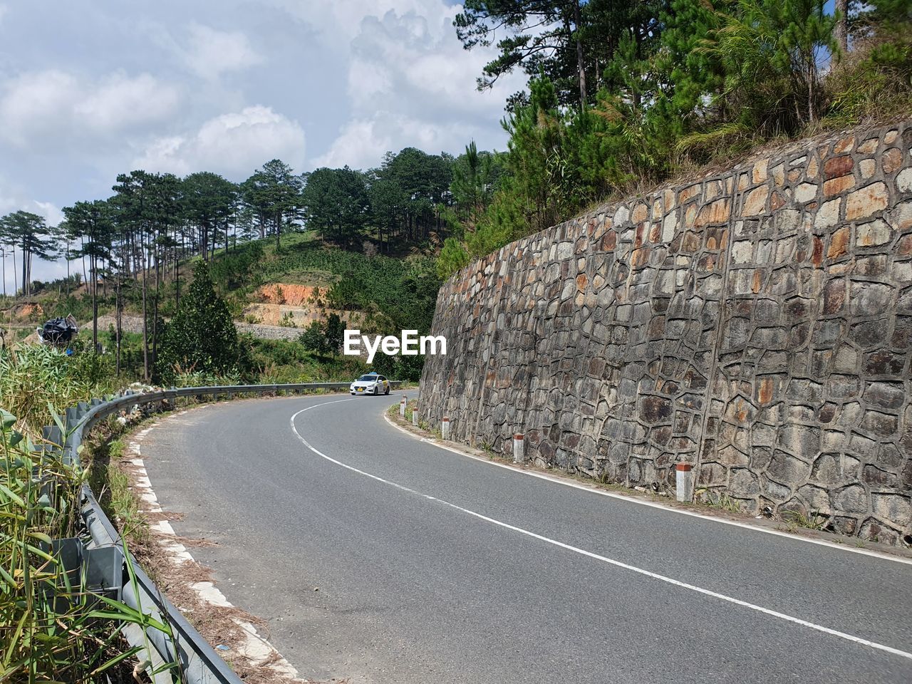 road, transportation, tree, plant, lane, road surface, nature, sky, symbol, architecture, infrastructure, cloud, city, street, wall, no people, day, residential area, curve, sign, highway, road marking, the way forward, outdoors, built structure, asphalt, marking, travel, travel destinations, land, empty road