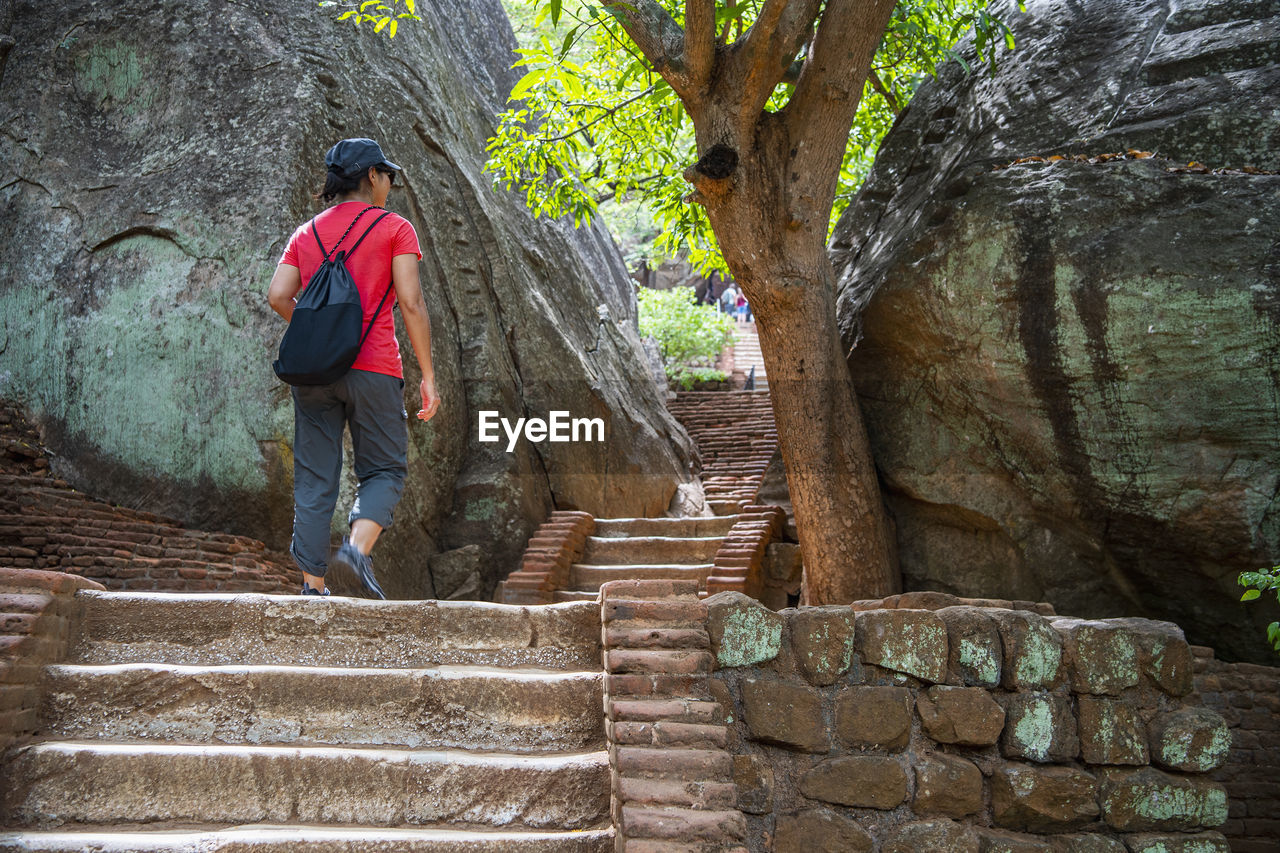 Woman climbing up the stairs towards the rock fortress of sigiriya