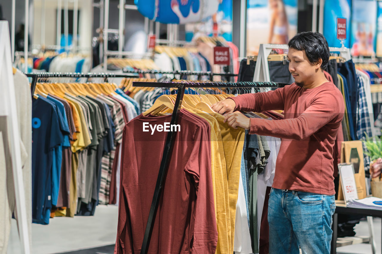 Man choosing t-shirts at store