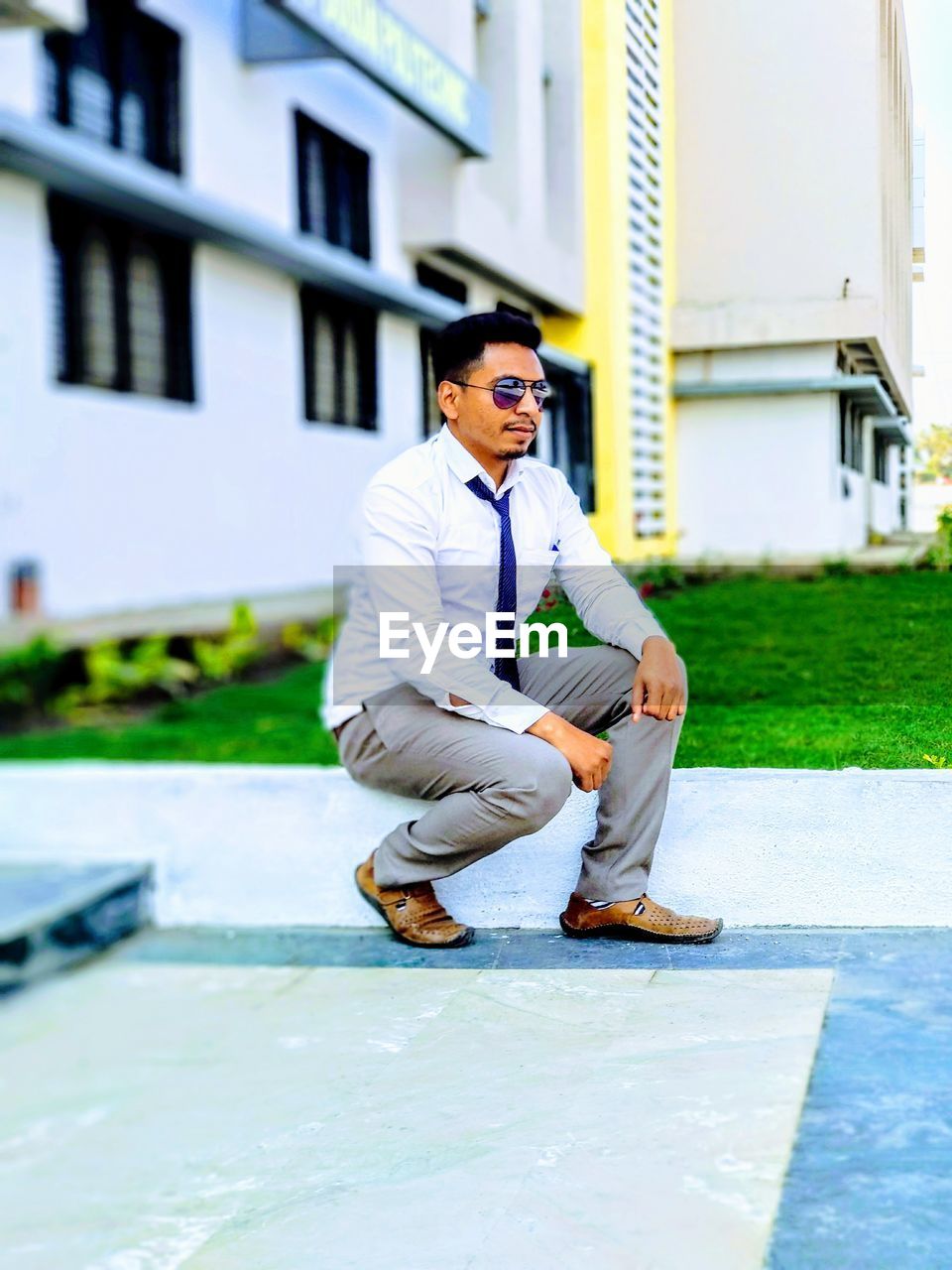 Young man crouching on walkway