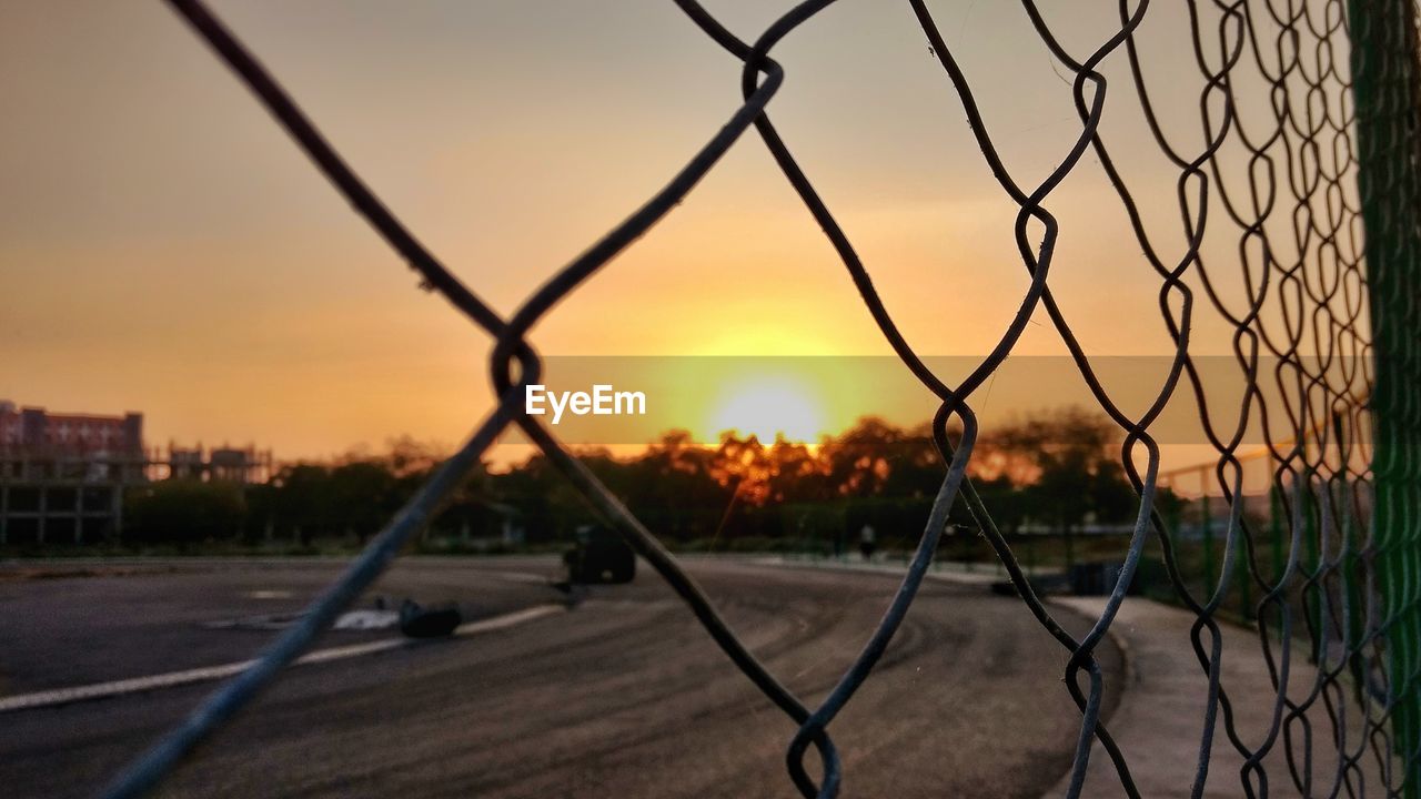 CLOSE-UP OF CHAINLINK FENCE AT SUNSET