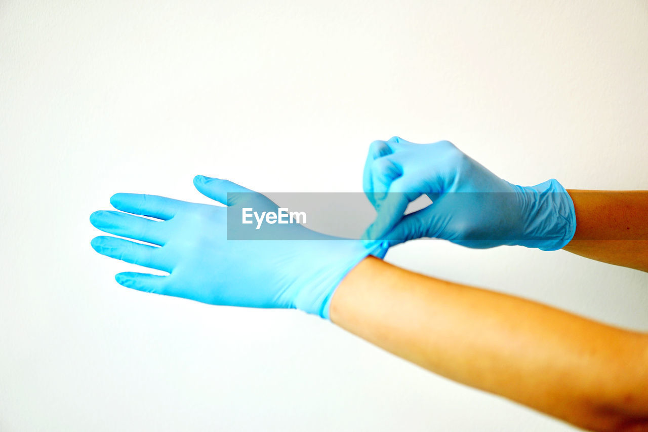 hand, protective glove, arm, blue, finger, protective workwear, protection, indoors, healthcare and medicine, limb, adult, surgical glove, glove, cleaning, close-up, safety glove, occupation, washing up glove, studio shot, cleanliness, security, scrubbing