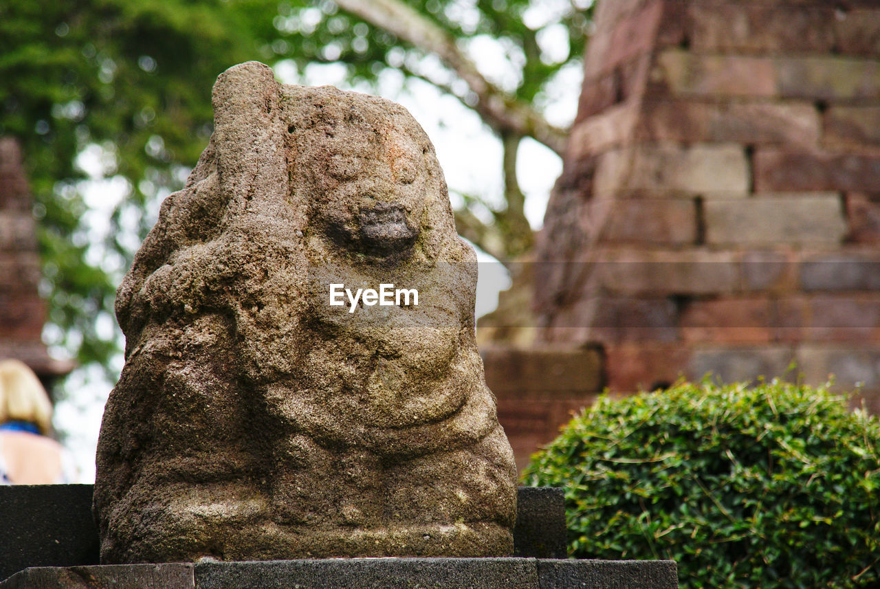 Close-up of ancient statue against temple