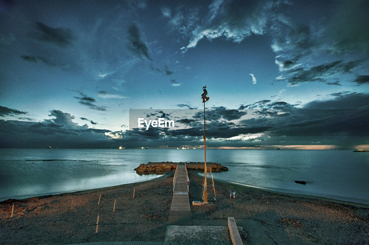 Pier over sea against sky at sunset