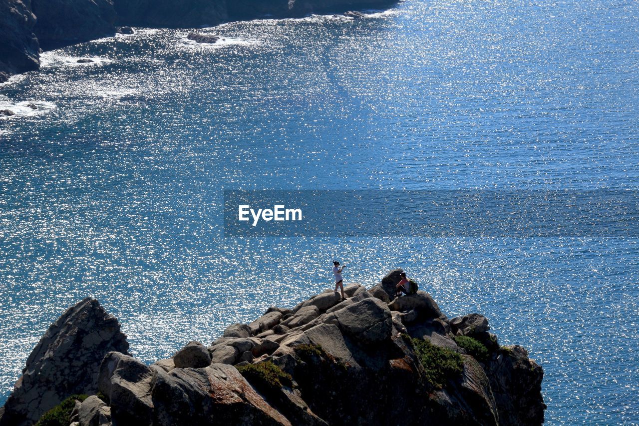 HIGH ANGLE VIEW OF ROCK FORMATIONS BY SEA