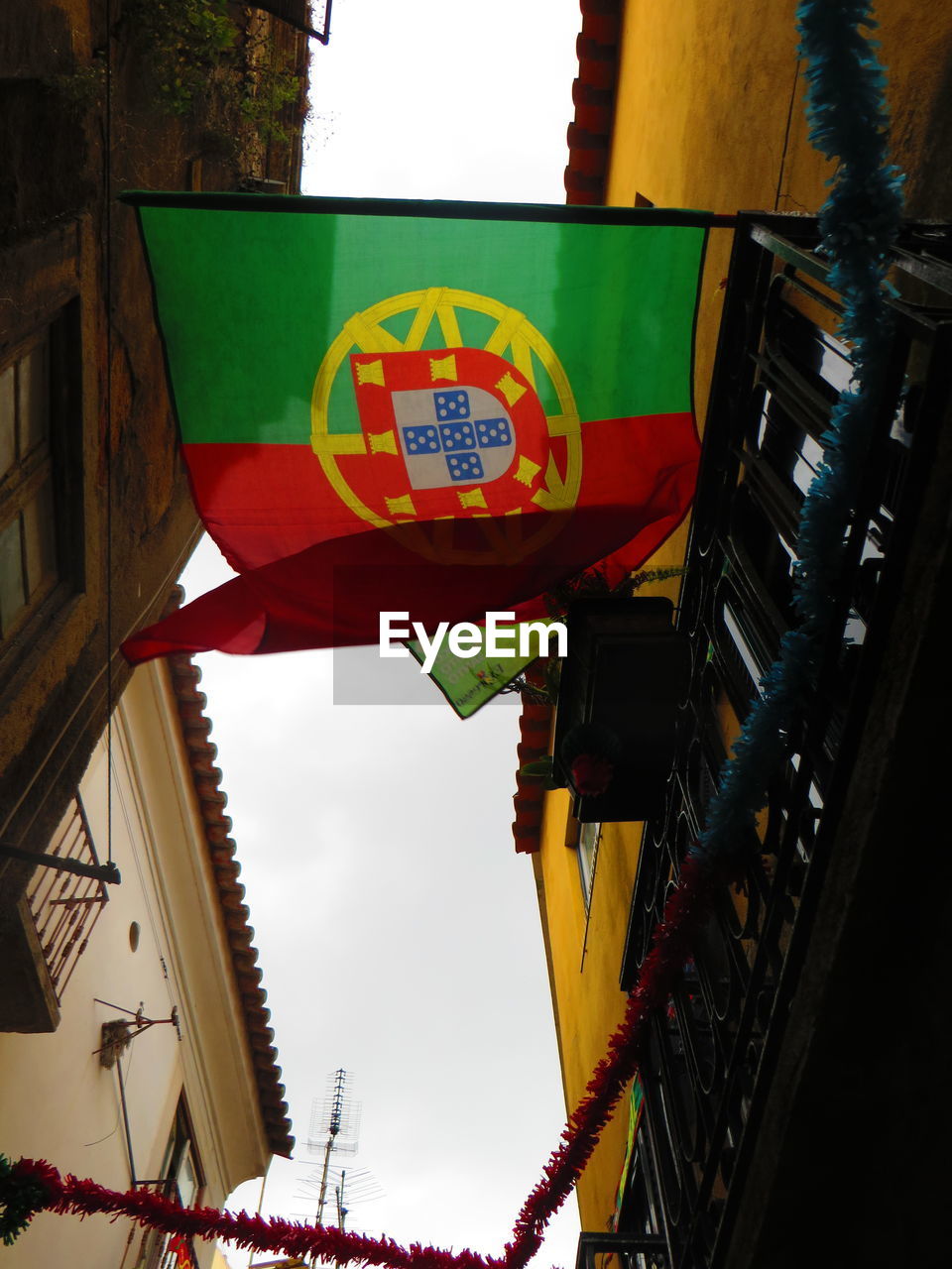 LOW ANGLE VIEW OF FLAGS HANGING FROM BUILDING