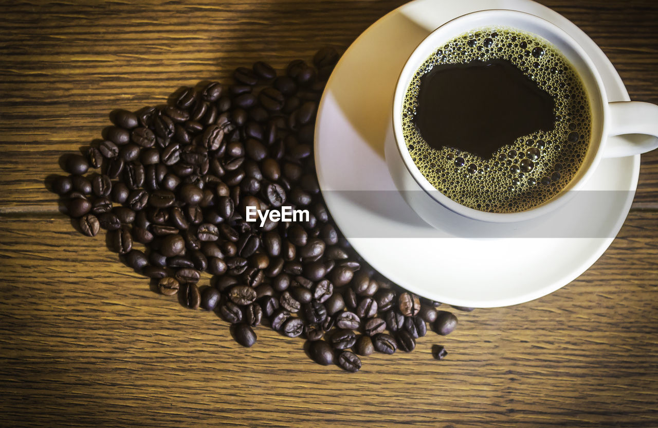 HIGH ANGLE VIEW OF COFFEE CUP ON WOODEN TABLE