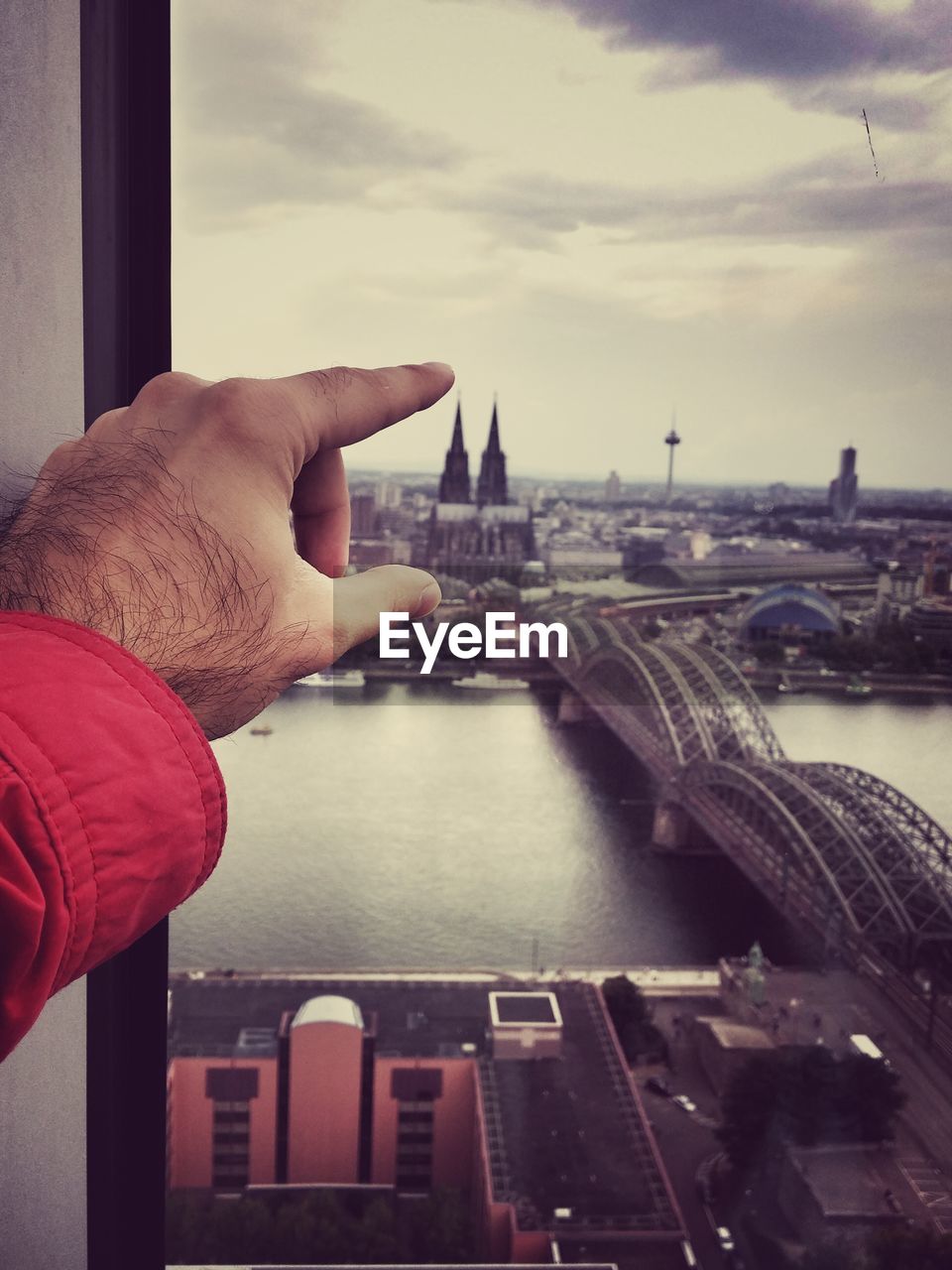 Cropped hand of man pointing towards cologne cathedral in city