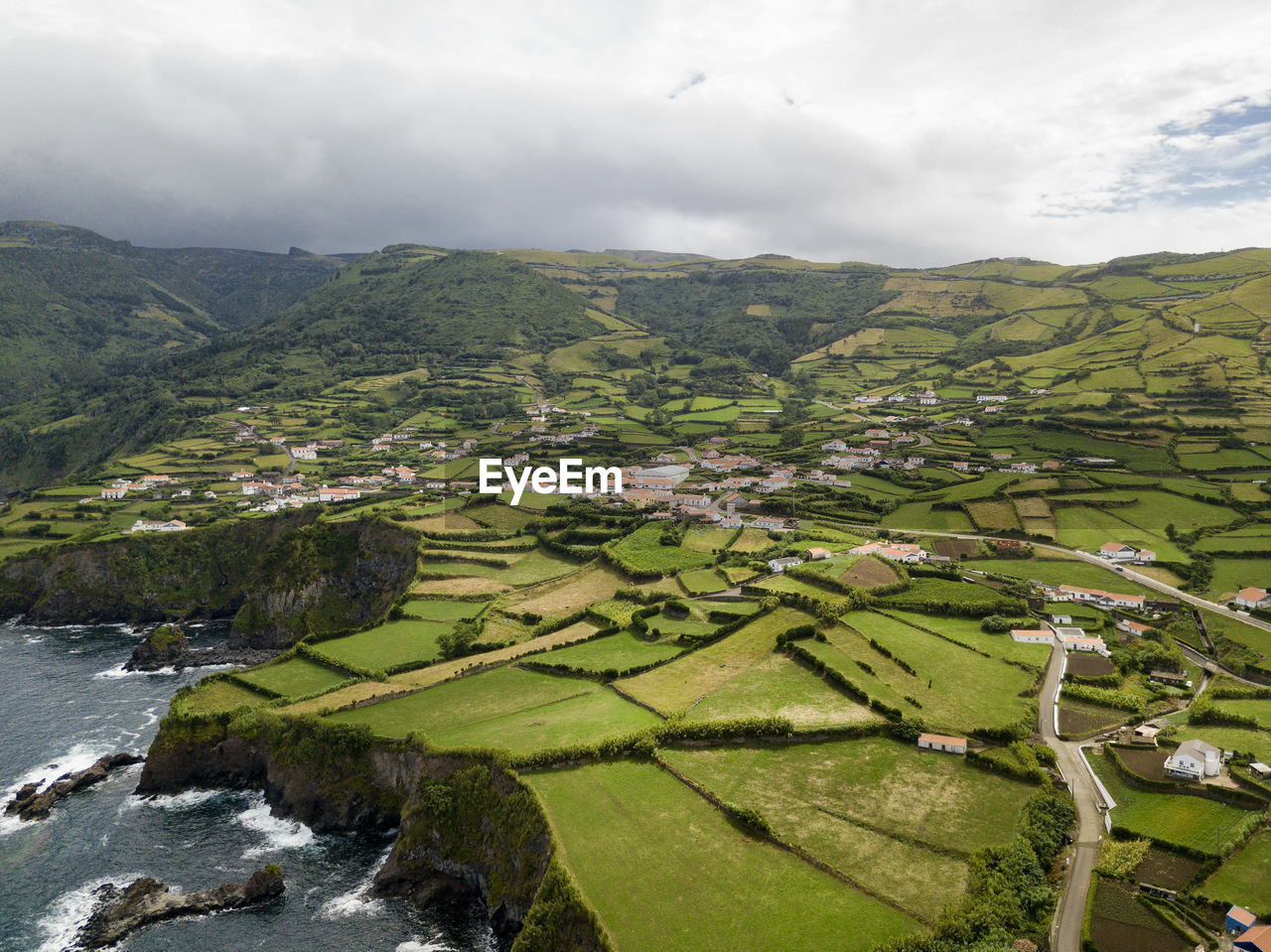 SCENIC VIEW OF AGRICULTURAL FIELD AND MOUNTAINS AGAINST SKY