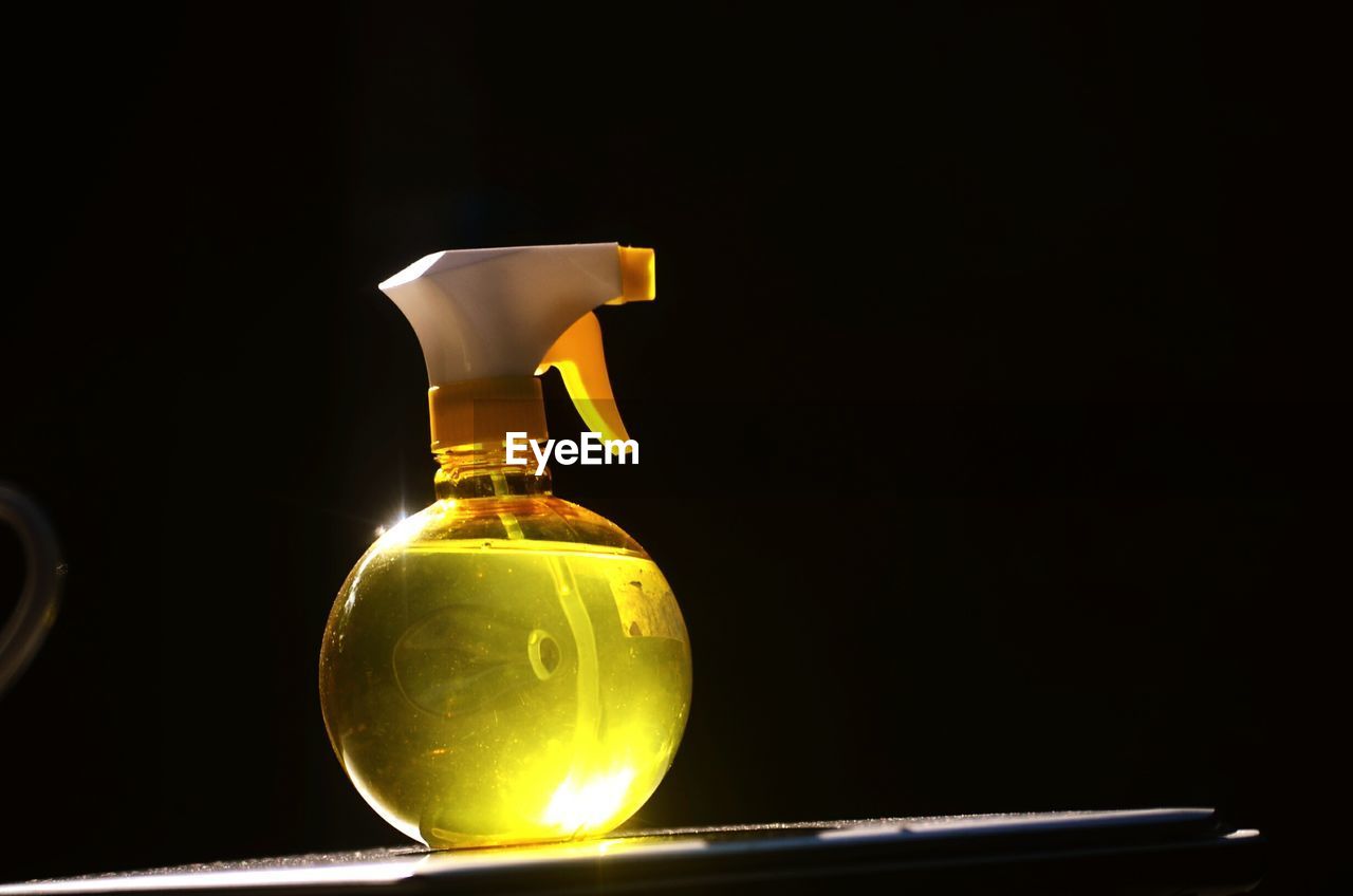 Close-up of spray bottle on table in darkroom