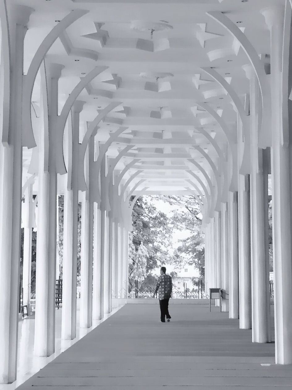 Man walking under arcade