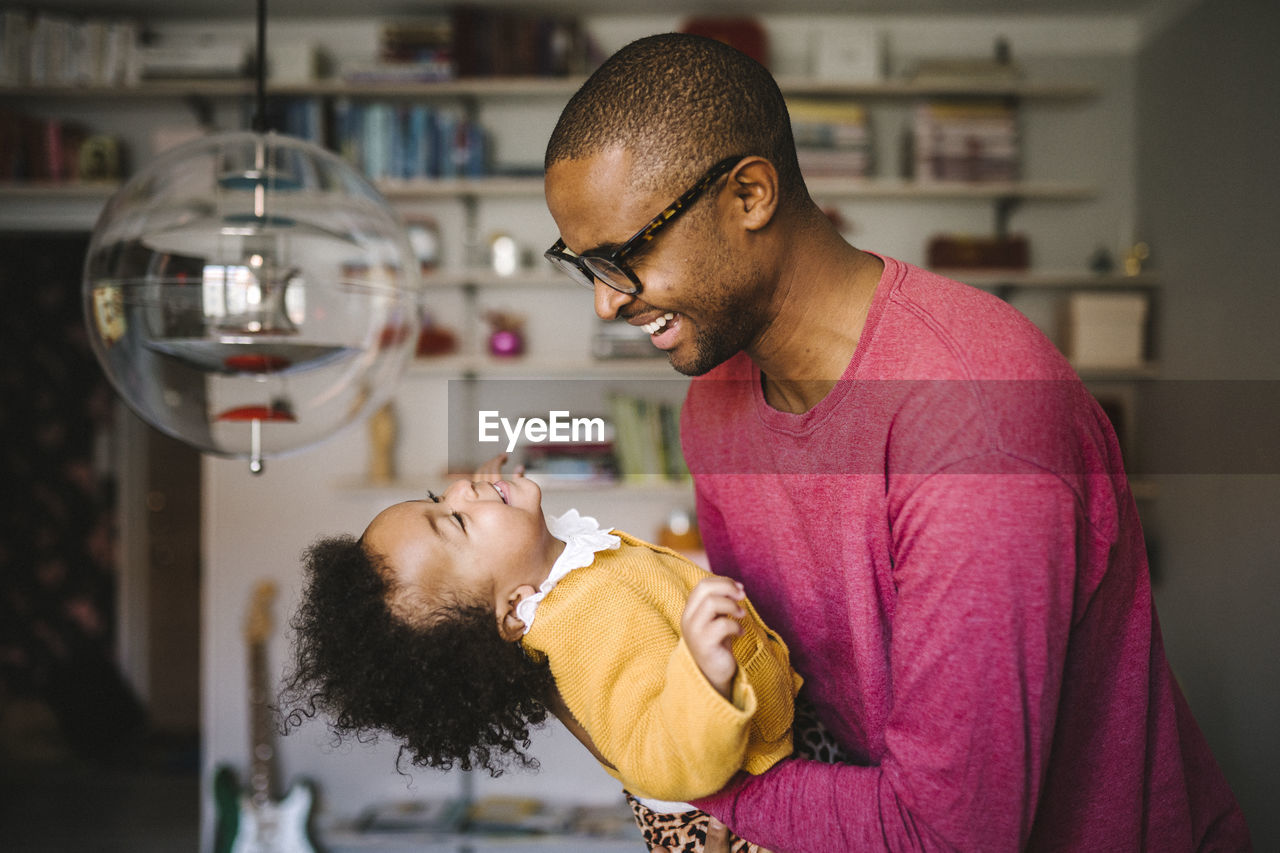 Young father holding smiling daughter