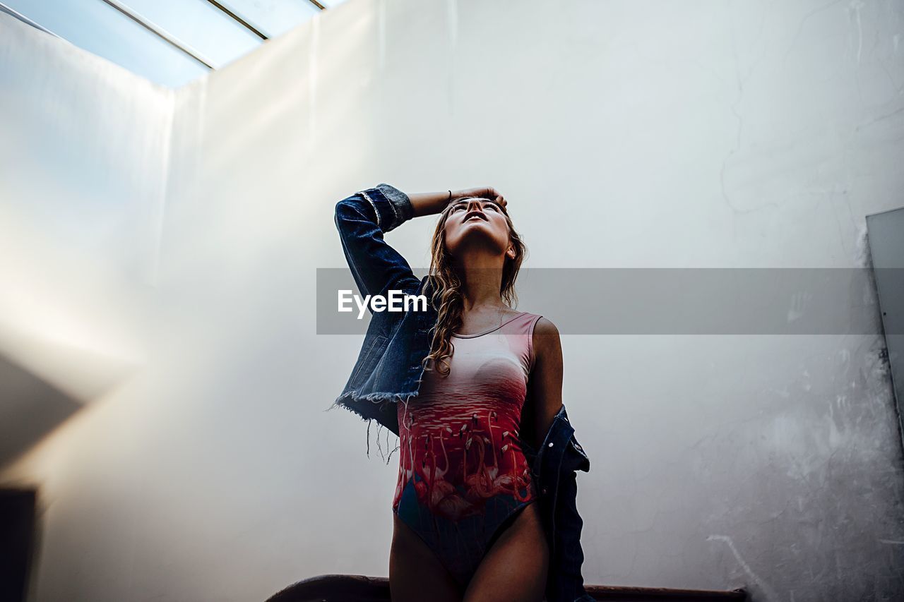 YOUNG WOMAN STANDING ON FLOOR