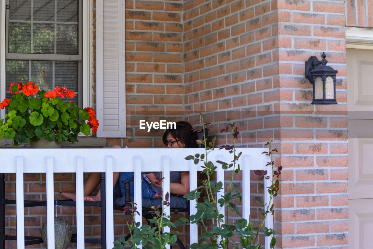 Side view of mid adult woman sitting in balcony