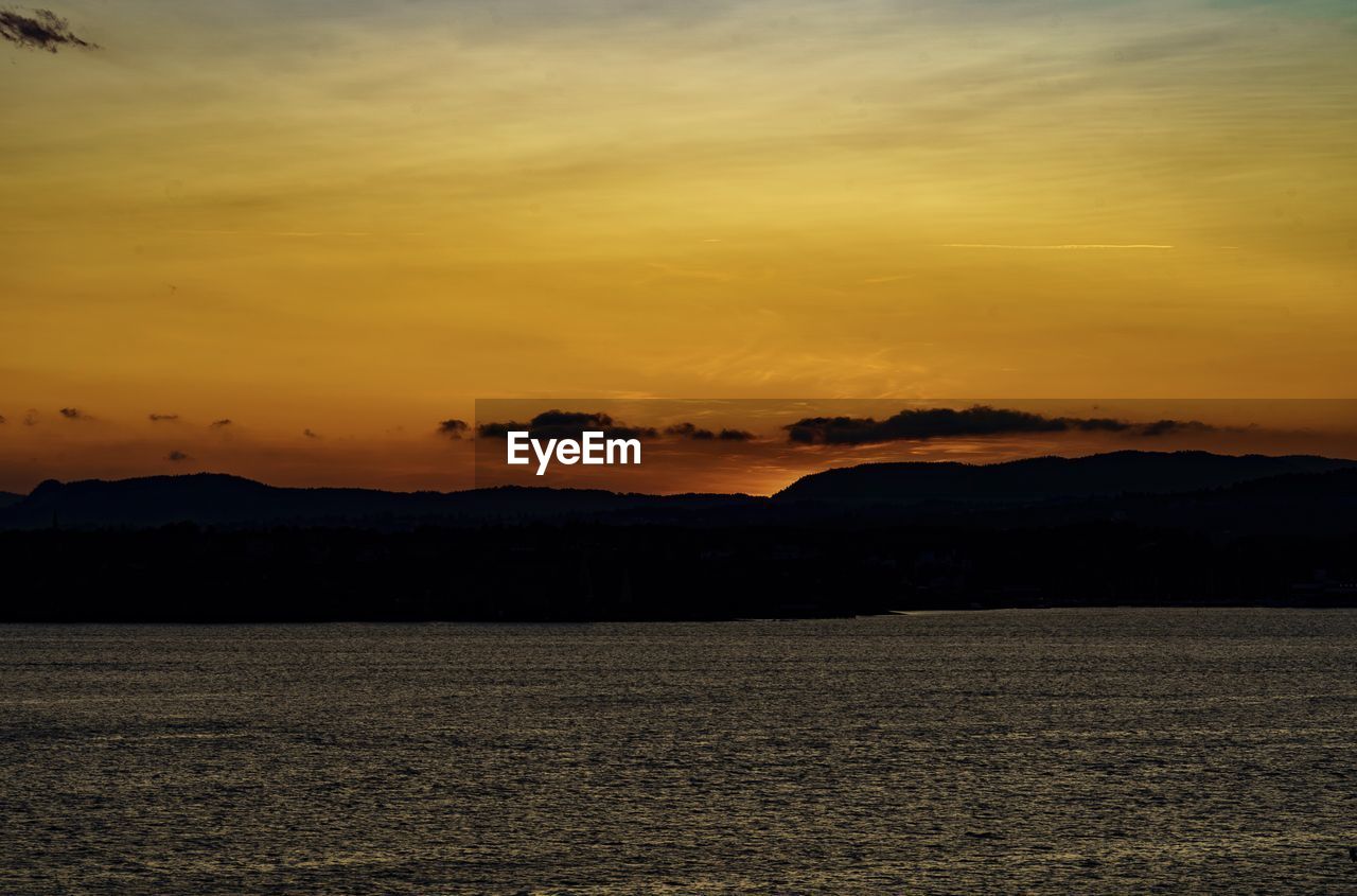 SCENIC VIEW OF SEA AGAINST ORANGE SKY