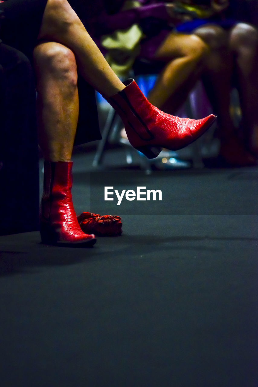 human leg, shoe, adult, red, low section, performance art, footwear, high heels, one person, human limb, limb, lifestyles, performing arts, indoors, women, dancing, sitting, arts culture and entertainment, sports, entertainment, men