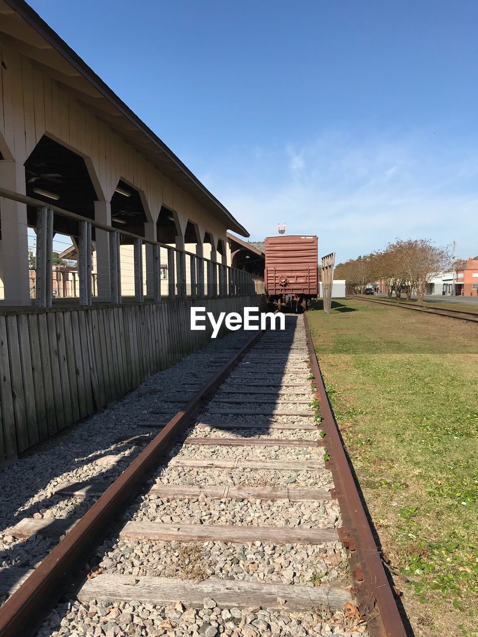 RAILROAD TRACKS AMIDST BUILDINGS AGAINST SKY