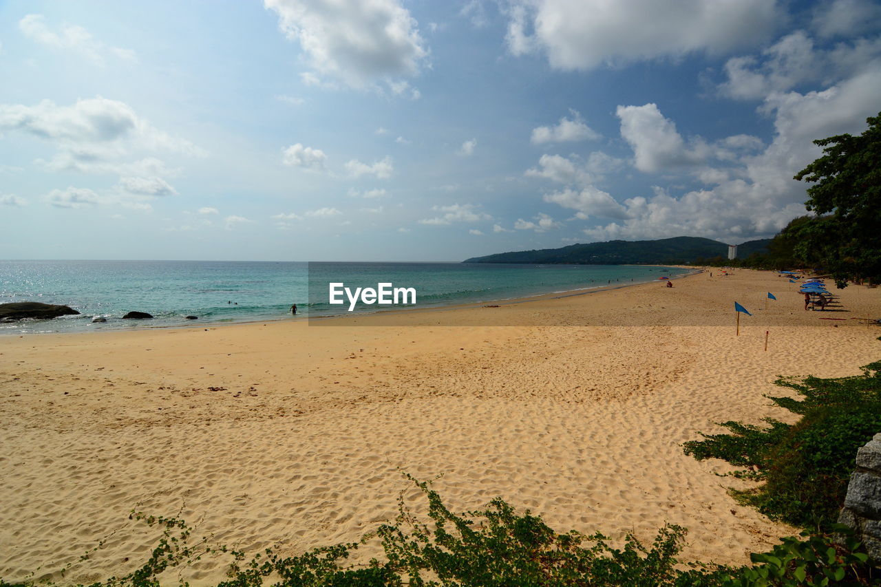 Scenic view of beach against cloudy sky