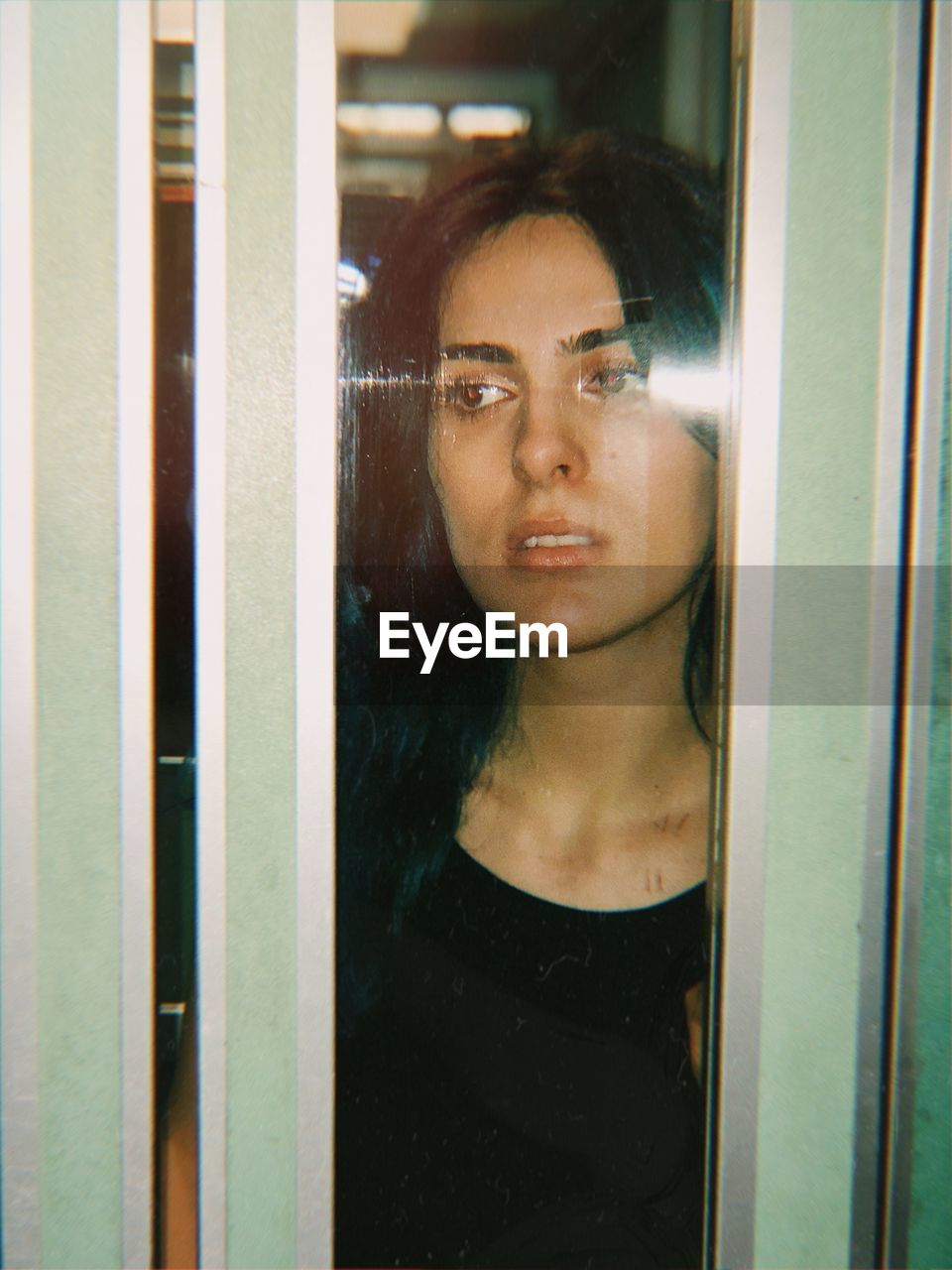 Thoughtful young woman seen through elevator