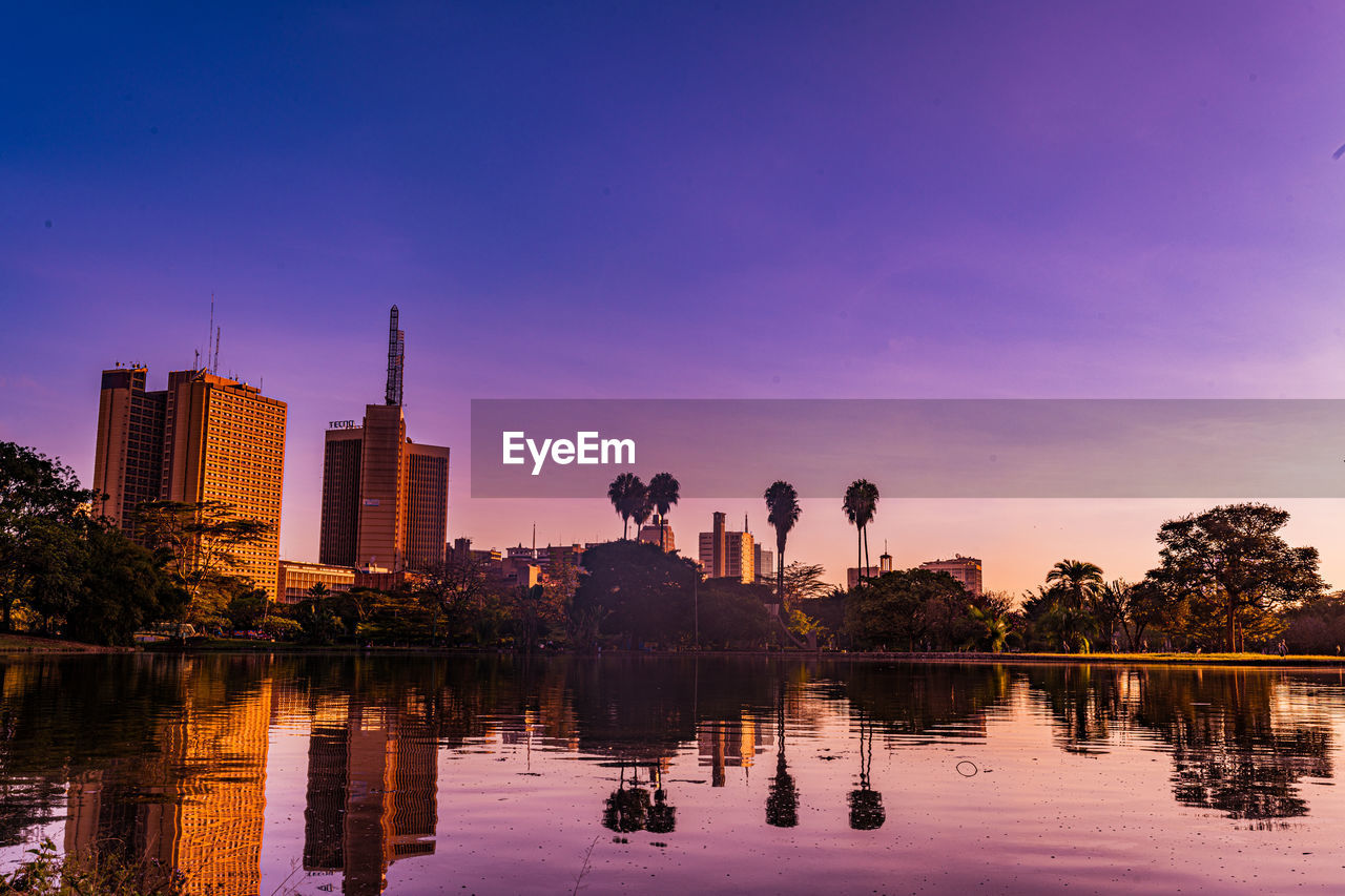 reflection, dusk, evening, water, skyline, sky, architecture, city, built structure, landscape, sunset, cityscape, building exterior, nature, building, horizon, travel destinations, urban skyline, twilight, lake, skyscraper, office building exterior, travel, night, tree, environment, beauty in nature, business finance and industry, outdoors, cloud, plant, tranquility, no people, tourism, scenics - nature, blue